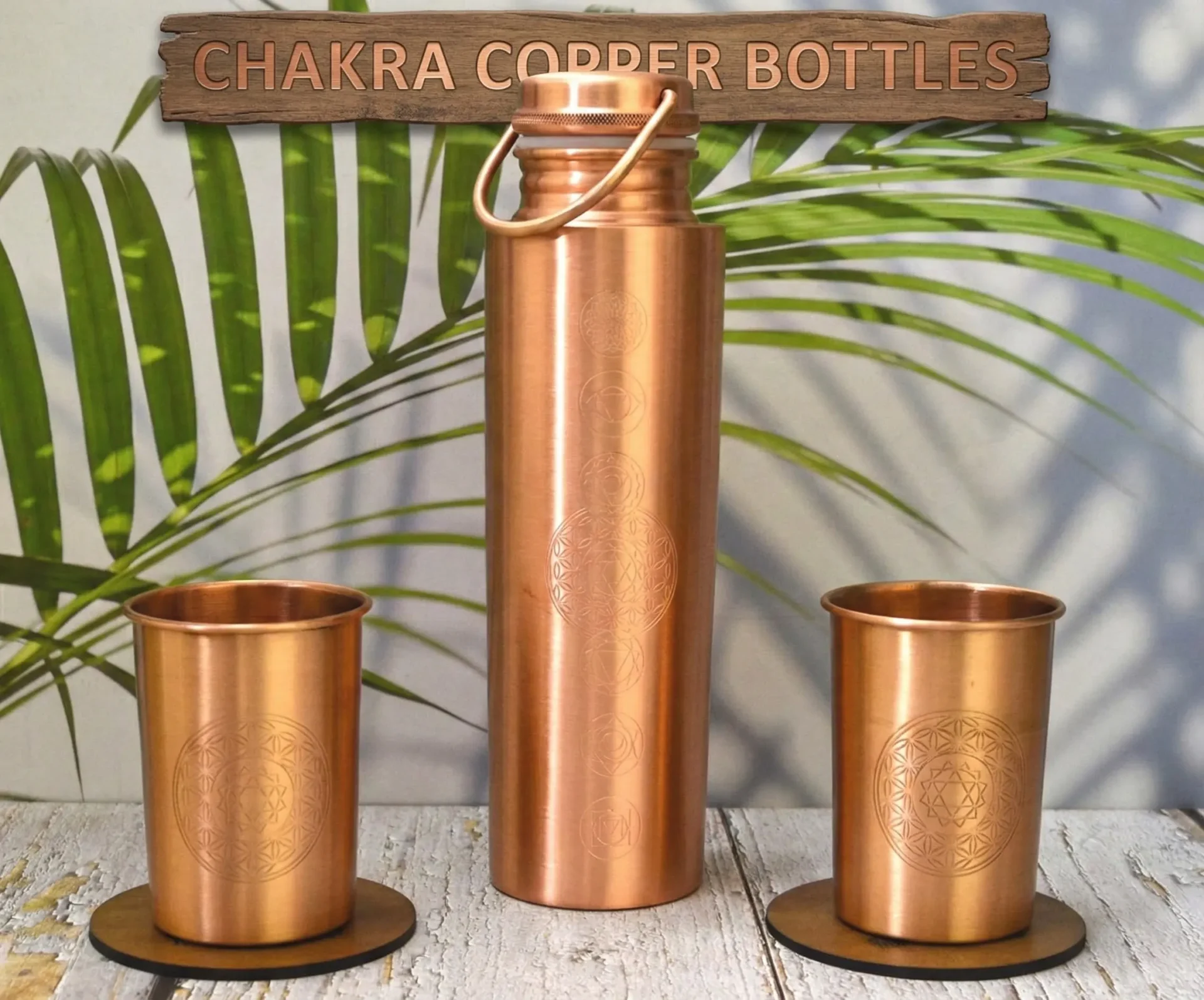 Handcrafted 100% pure copper water bottle with seven colorful chakra symbols engraved vertically. Features a polished metallic finish and a secure screw-top lid on a minimalist white background.